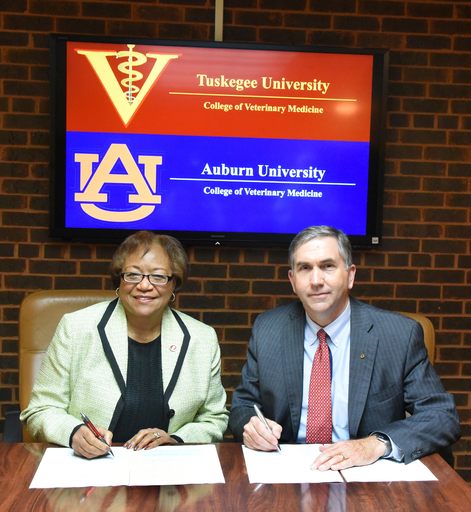 Tuskegee veterinary Dean Ruby Perry, and Auburn veterinary Dean Calvin Johnson sign the agreement.