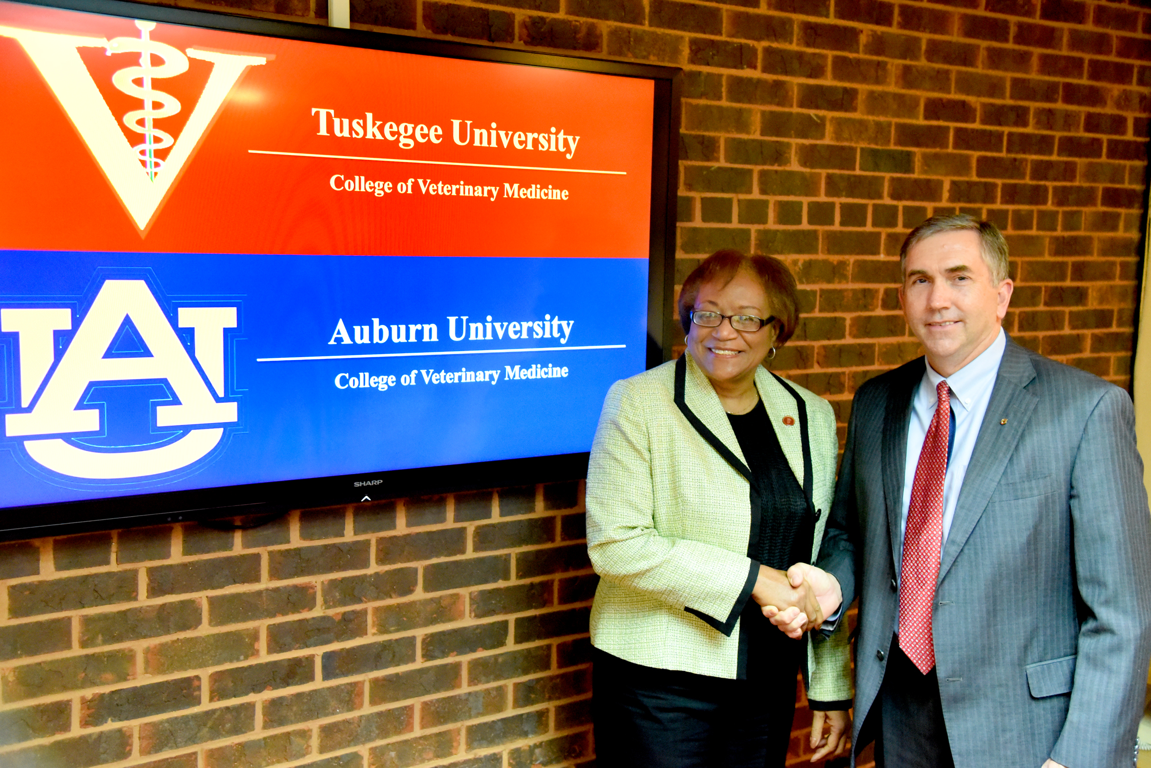 Dean Ruby Perry and Dean Calvin Johnson shake hands after signing the MOU.