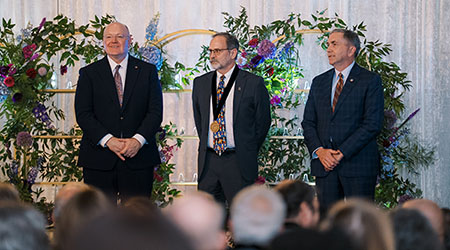 Dr. Michael Tillson (center). Pictured with him (left to right) are Auburn University President Christopher Roberts and College of Veterinary Medicine Dean Calvin Johnson.